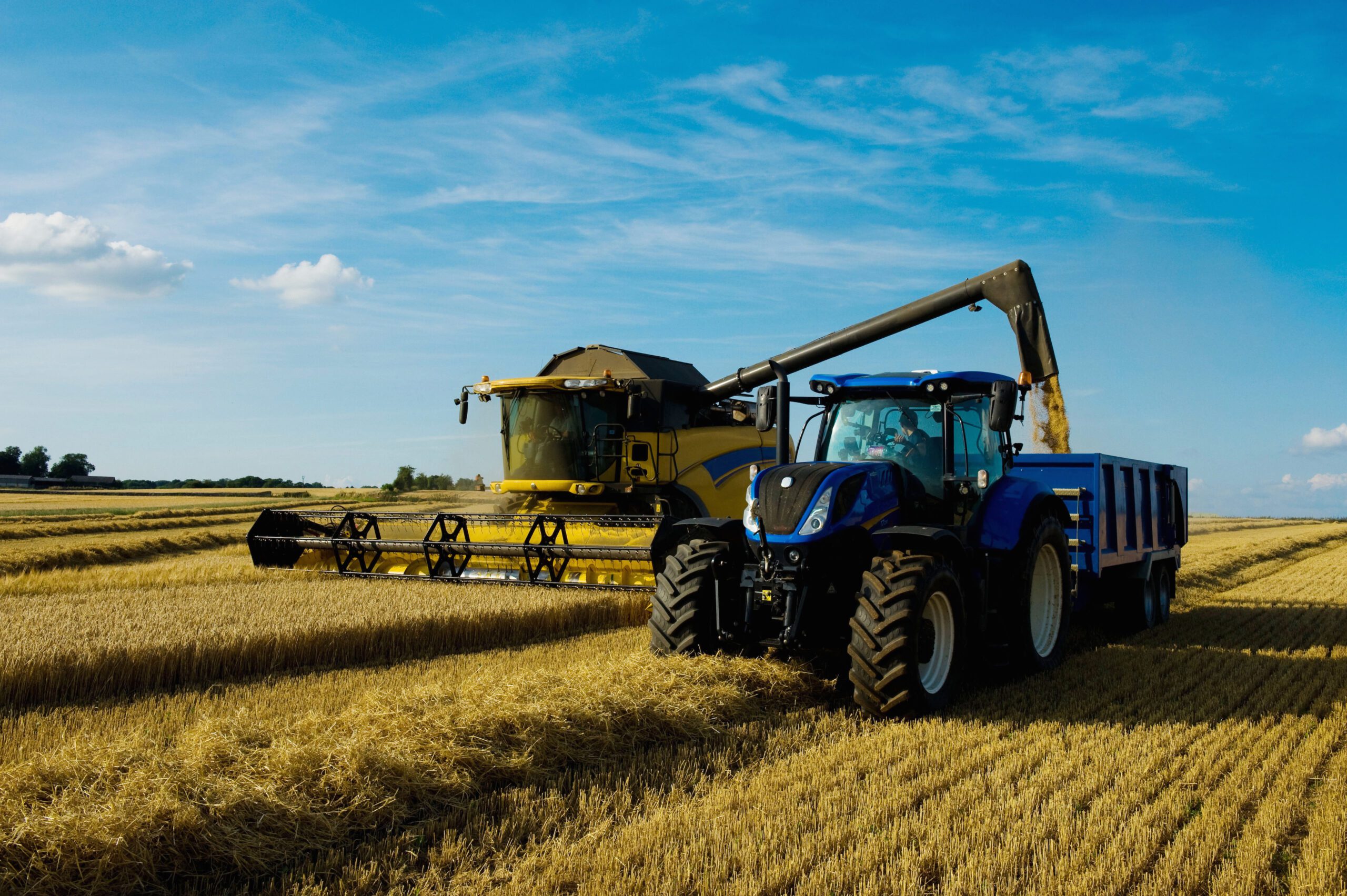 Modern combine harvester and tractor harvesting crops with Sleemans agricultural engines